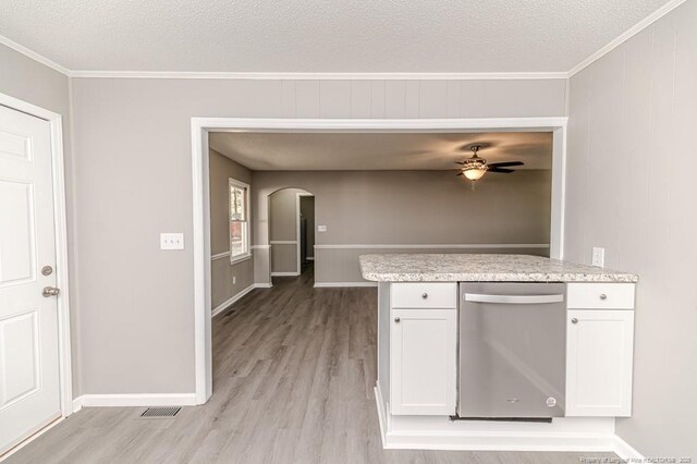 kitchen featuring stainless steel dishwasher, arched walkways, ornamental molding, and light wood-style floors