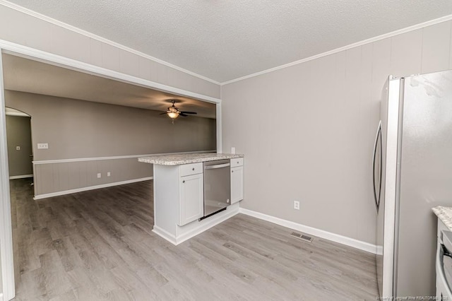 kitchen featuring ceiling fan, visible vents, appliances with stainless steel finishes, ornamental molding, and light wood-style flooring