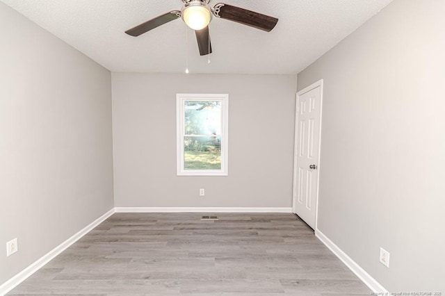 unfurnished room with a ceiling fan, baseboards, and light wood-style floors