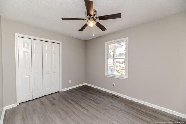 unfurnished bedroom with visible vents, baseboards, and wood finished floors