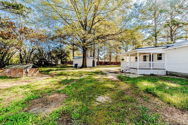 view of yard featuring a porch, an outbuilding, and a storage unit