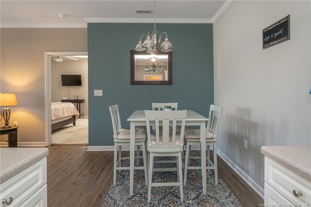 3159 Wisteria Ln Unit 101, Fayetteville, NC 28314 - dining space featuring crown molding, an inviting chandelier, baseboards, dark wood-style floors, and visible vents