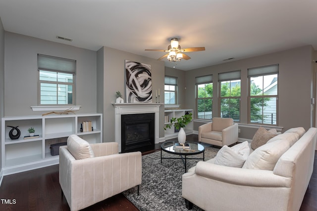 4026 Overcup Oak Ln, Cary, NC 27519 - living room with dark wood-type flooring, healthy amount of natural light, a glass covered fireplace, and a ceiling fan