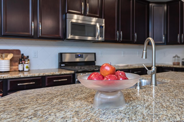 4026 Overcup Oak Ln, Cary, NC 27519 - kitchen featuring appliances with stainless steel finishes, backsplash, light stone countertops, and dark brown cabinetry