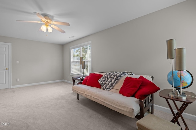 carpeted living area featuring baseboards and ceiling fan