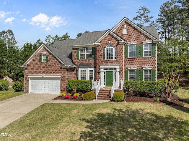 colonial inspired home with driveway, a front lawn, and brick siding