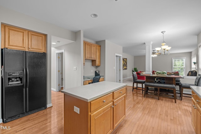 kitchen featuring open floor plan, light wood-style floors, a chandelier, and black fridge with ice dispenser