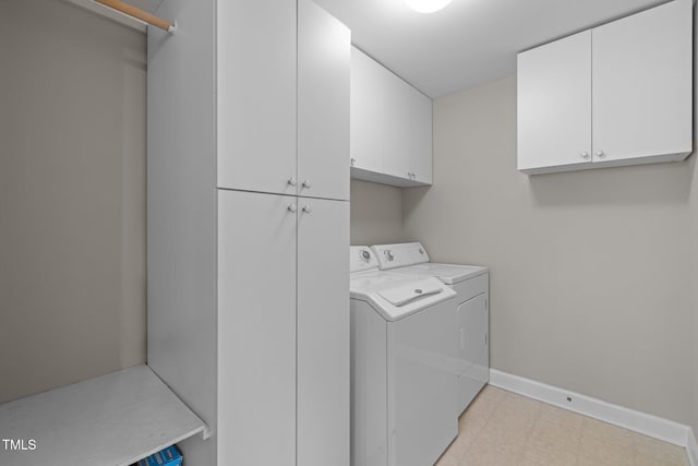 laundry room featuring washing machine and dryer, baseboards, light floors, and cabinet space