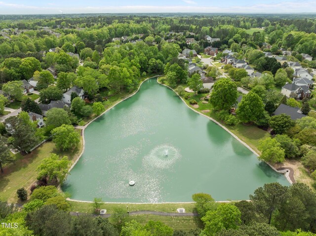 drone / aerial view featuring a water view and a wooded view