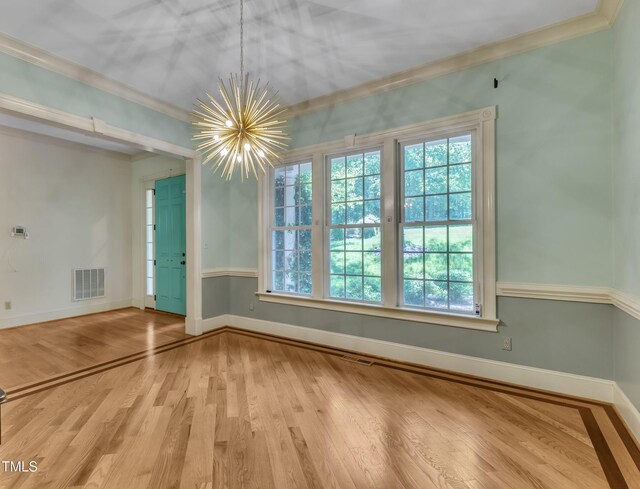85 Christenbury Ln, Clayton, NC 27527 - unfurnished dining area with plenty of natural light, crown molding, wood finished floors, and a chandelier