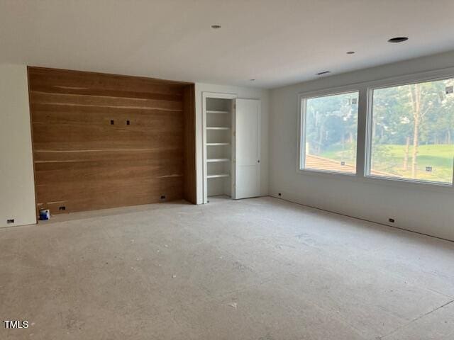 1216 Barcroft Pl, Raleigh, NC 27615 - unfurnished bedroom featuring multiple windows and wood walls