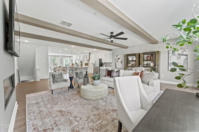 1245 S Blount St Unit 201, Raleigh, NC 27601 - living area featuring visible vents, light wood-type flooring, beamed ceiling, and ceiling fan
