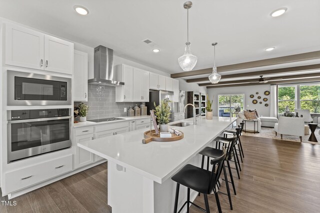 1245 S Blount St Unit 201, Raleigh, NC 27601 - kitchen with wall chimney range hood, light countertops, visible vents, stainless steel appliances, and a sink
