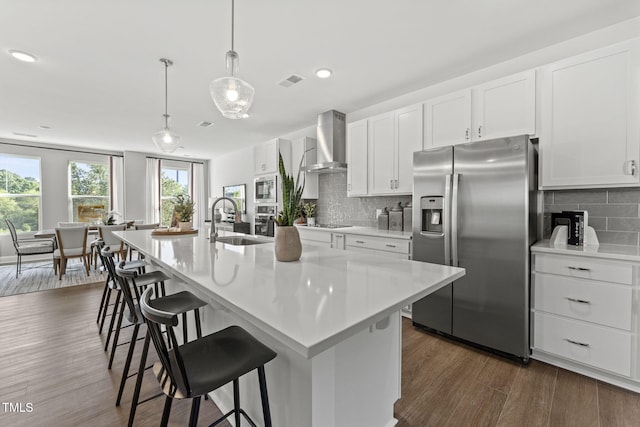 1245 S Blount St Unit 201, Raleigh, NC 27601 - kitchen with wall chimney range hood, visible vents, a center island with sink, stainless steel appliances, and a sink