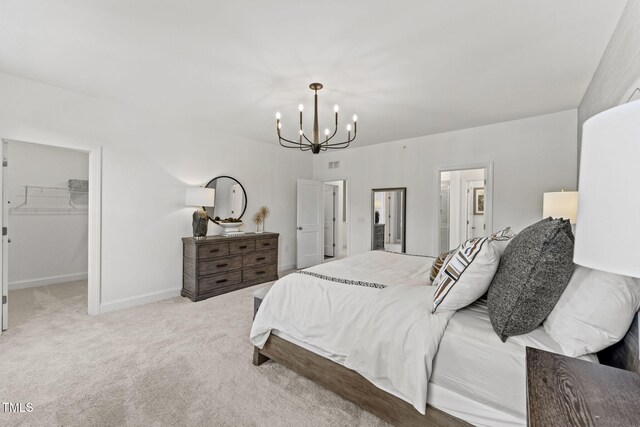 1245 S Blount St Unit 201, Raleigh, NC 27601 - bedroom featuring baseboards, a closet, light carpet, a spacious closet, and a chandelier