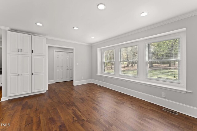 2949 Tram Rd, Fuquay Varina, NC 27526 - unfurnished bedroom featuring dark wood-style floors, visible vents, crown molding, and baseboards