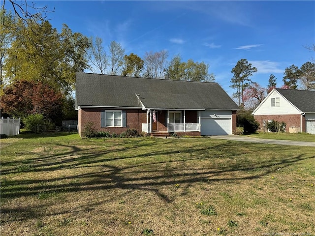 5870 Mcdonald Rd, Parkton, NC 28371 - view of front of house featuring covered porch, driveway, brick siding, a front lawn, and an attached garage