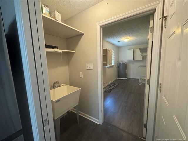 5870 Mcdonald Rd, Parkton, NC 28371 - laundry room with baseboards, a sink, a textured ceiling, and dark wood-style flooring