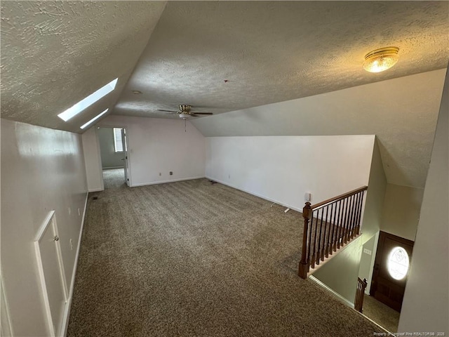 5870 Mcdonald Rd, Parkton, NC 28371 - bonus room featuring ceiling fan, vaulted ceiling with skylight, a textured ceiling, carpet, and baseboards