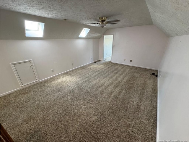 5870 Mcdonald Rd, Parkton, NC 28371 - bonus room featuring vaulted ceiling with skylight, a ceiling fan, a textured ceiling, carpet floors, and baseboards