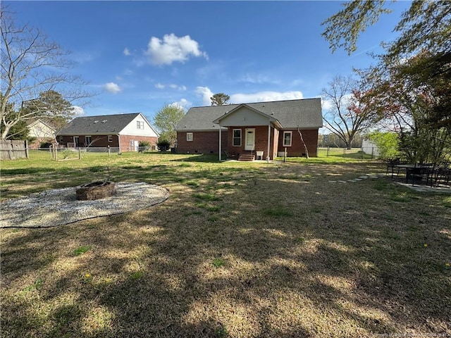 5870 Mcdonald Rd, Parkton, NC 28371 - back of house with brick siding, a fire pit, fence, and a yard