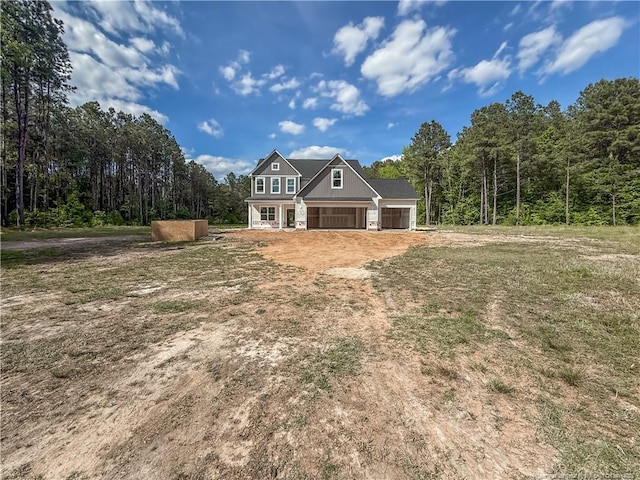 1312 Cory Cir, Fayetteville, NC 28312 - view of front of house with a garage, dirt driveway, and a forest view
