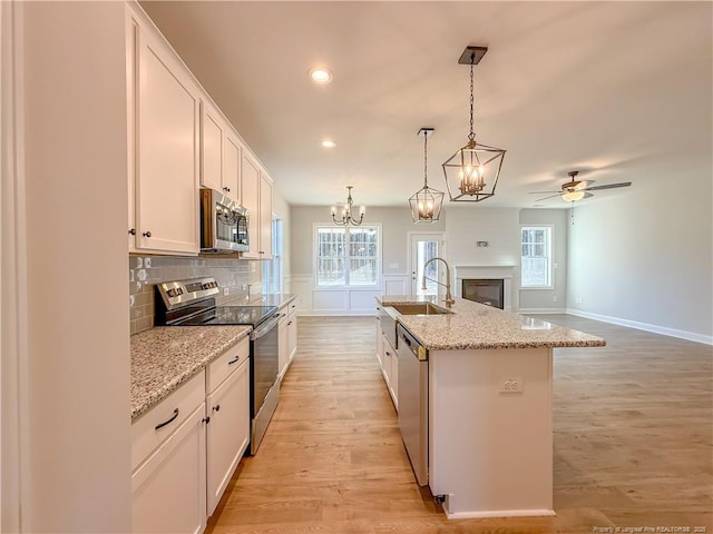1312 Cory Cir, Fayetteville, NC 28312 - kitchen featuring baseboards, white cabinets, tasteful backsplash, a sink, and stainless steel appliances