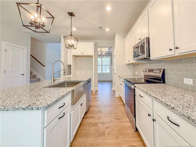 1312 Cory Cir, Fayetteville, NC 28312 - kitchen featuring stainless steel appliances, a chandelier, a sink, and light wood-style flooring
