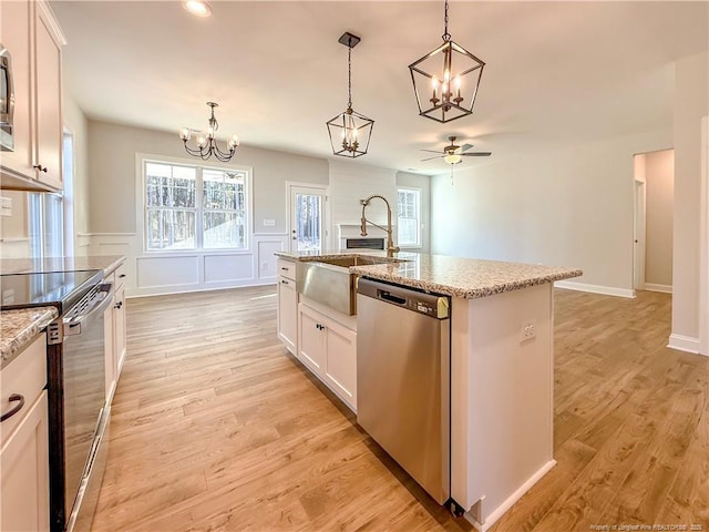 1312 Cory Cir, Fayetteville, NC 28312 - kitchen featuring a kitchen island with sink, appliances with stainless steel finishes, light stone countertops, ceiling fan with notable chandelier, and white cabinetry