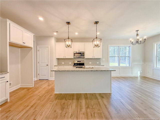 1312 Cory Cir, Fayetteville, NC 28312 - kitchen with backsplash, decorative light fixtures, white cabinets, a notable chandelier, and stainless steel appliances