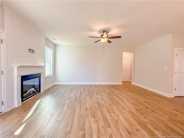 1312 Cory Cir, Fayetteville, NC 28312 - unfurnished living room featuring ceiling fan, light wood finished floors, a glass covered fireplace, baseboards, and visible vents