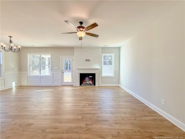 1312 Cory Cir, Fayetteville, NC 28312 - unfurnished living room featuring plenty of natural light, ceiling fan with notable chandelier, and light wood-style flooring