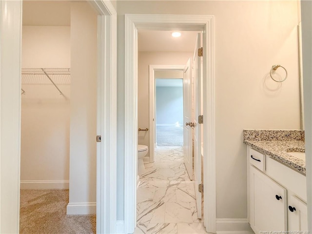 1312 Cory Cir, Fayetteville, NC 28312 - bathroom with vanity, baseboards, toilet, marble finish floor, and a spacious closet