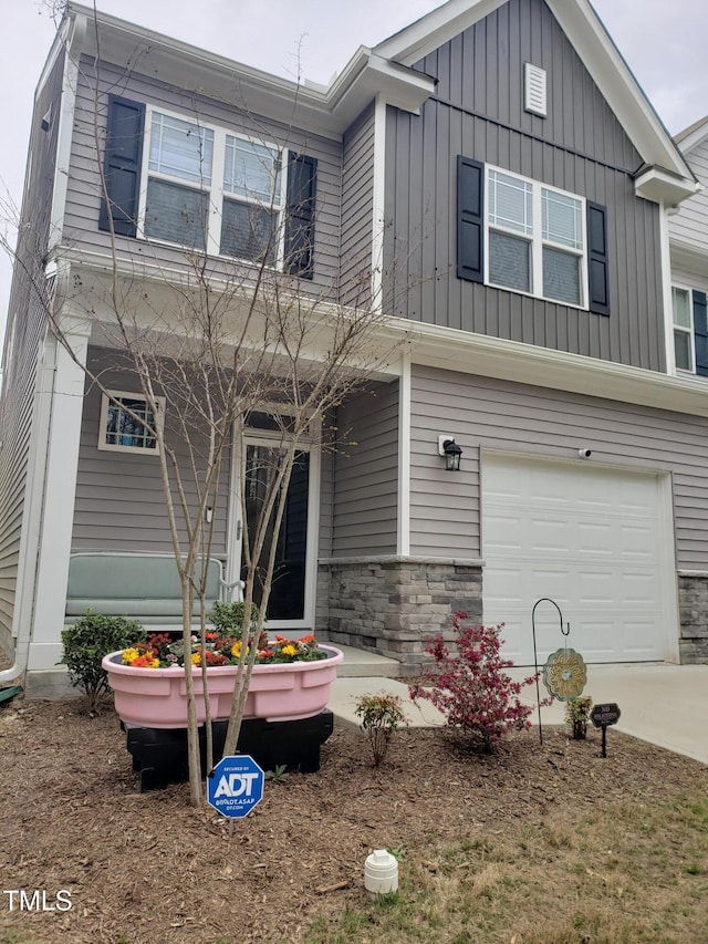 17 Verona Dr, Clayton, NC 27527 - view of front of home with a garage, driveway, board and batten siding, and stone siding