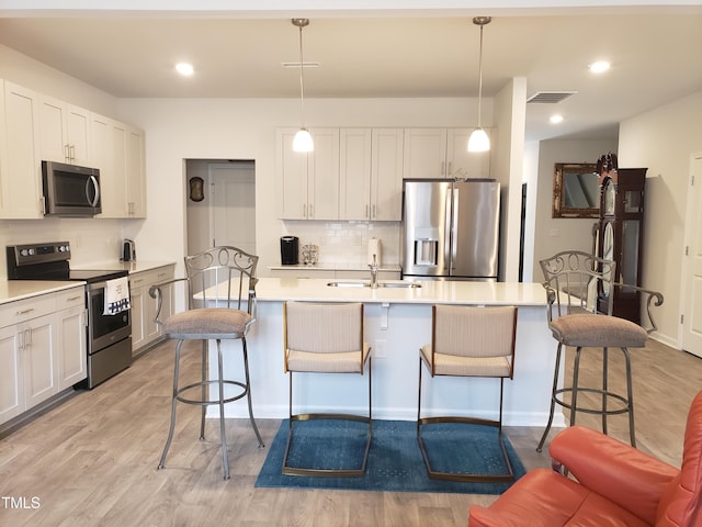 17 Verona Dr, Clayton, NC 27527 - kitchen featuring a sink, an island with sink, light wood-style floors, a kitchen bar, and stainless steel appliances