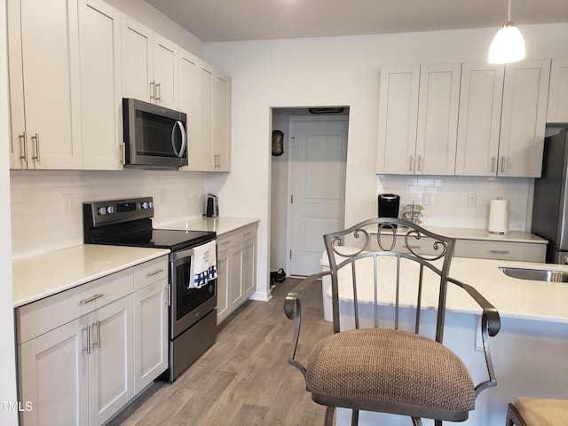 17 Verona Dr, Clayton, NC 27527 - kitchen with hanging light fixtures, light wood-type flooring, appliances with stainless steel finishes, and decorative backsplash