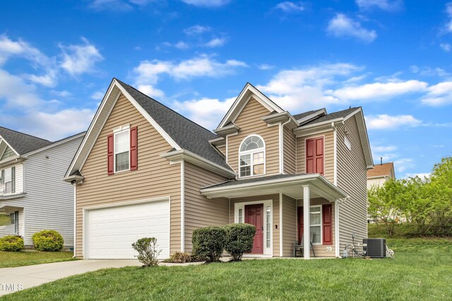 traditional-style home with a garage, cooling unit, concrete driveway, and a front lawn
