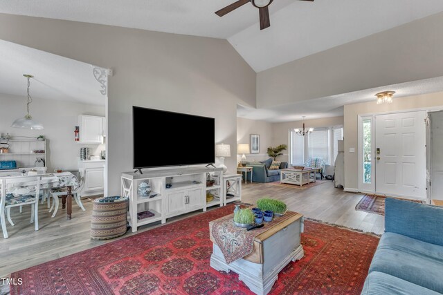 9512 Anson Grove Ln, Raleigh, NC 27615 - living room with light wood-style floors, ceiling fan with notable chandelier, and lofted ceiling