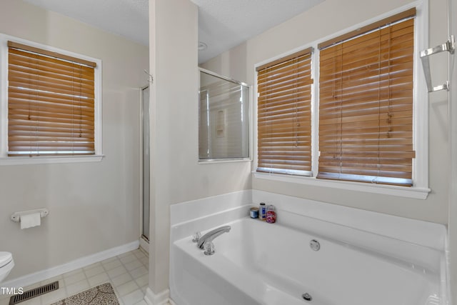 9512 Anson Grove Ln, Raleigh, NC 27615 - full bath with baseboards, a textured ceiling, a stall shower, a garden tub, and visible vents