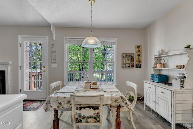 9512 Anson Grove Ln, Raleigh, NC 27615 - dining space featuring a fireplace, wood finished floors, and a textured ceiling
