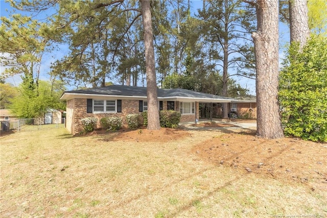 single story home with a carport, a front yard, fence, and brick siding