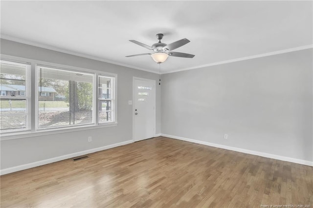 unfurnished room featuring ornamental molding, visible vents, baseboards, and wood finished floors
