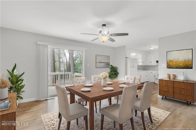 dining room with baseboards, light wood-type flooring, and a ceiling fan