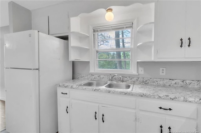 kitchen featuring a sink, open shelves, white cabinets, and freestanding refrigerator