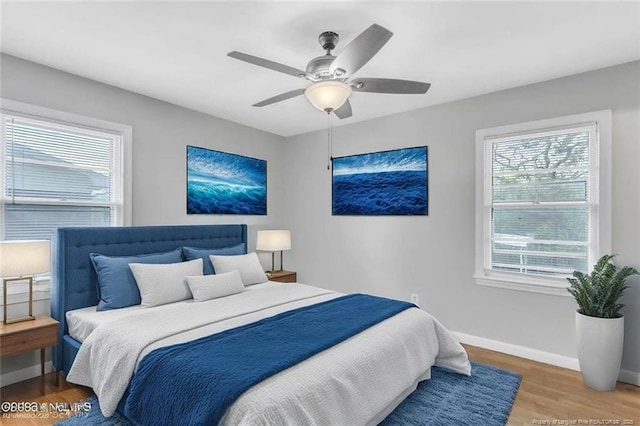 bedroom featuring ceiling fan, baseboards, and wood finished floors
