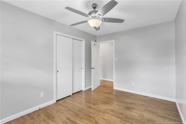 unfurnished bedroom with a closet, baseboards, and wood finished floors