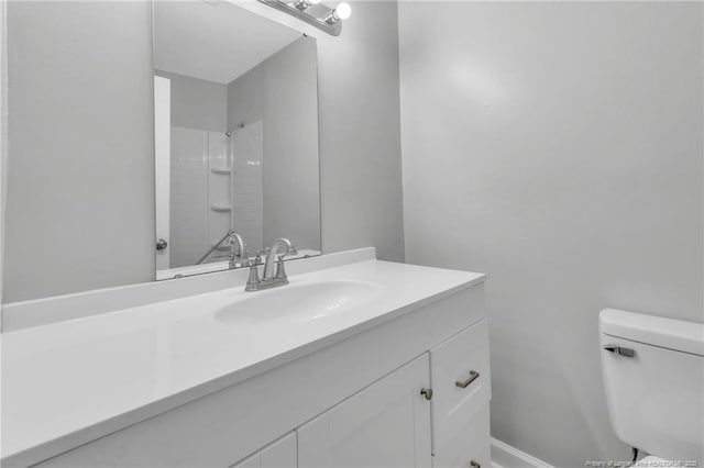 full bath featuring a shower, vanity, and toilet