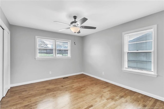 unfurnished bedroom with ceiling fan, a closet, light wood finished floors, and baseboards