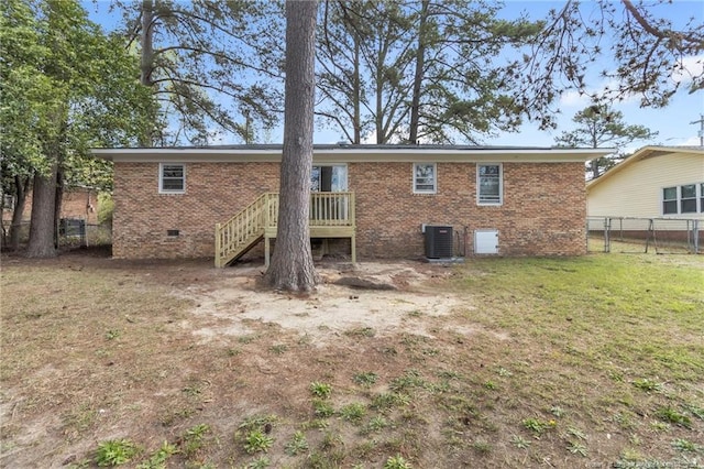 rear view of house featuring crawl space, central air condition unit, a yard, fence, and brick siding