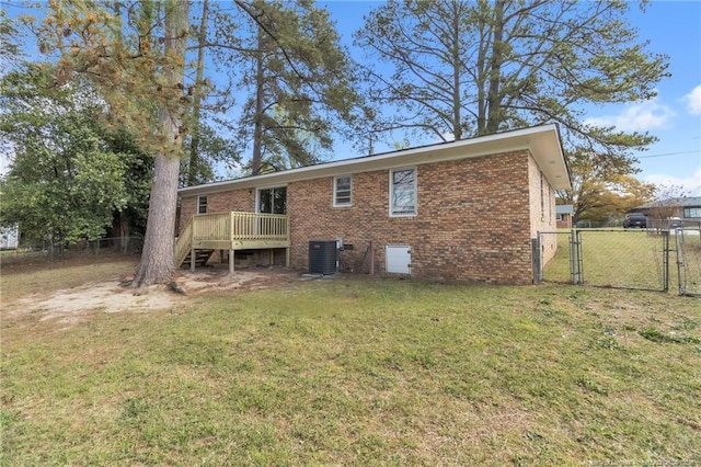 rear view of house featuring a wooden deck, central air condition unit, a yard, fence, and a gate